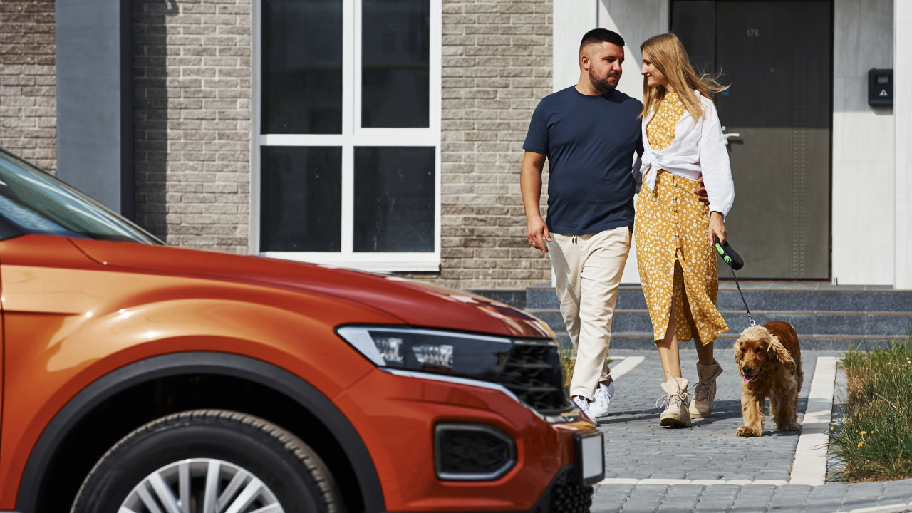 Couple walking down to car with dog