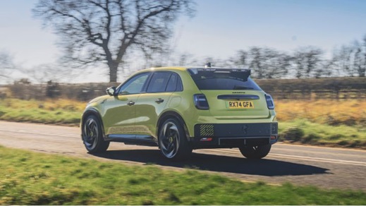 Yellow Abarth Driving On Road Rear