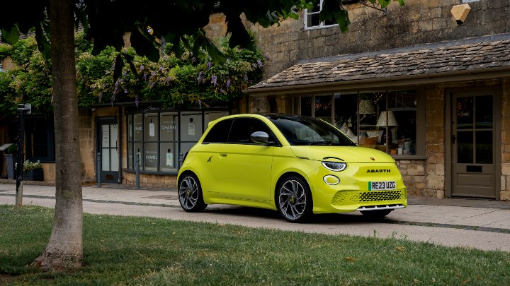 Yellow Abarth Driving On Road Front
