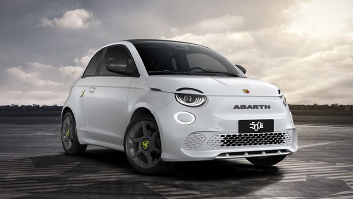 White Abarth 500e parked in front of a city skyline