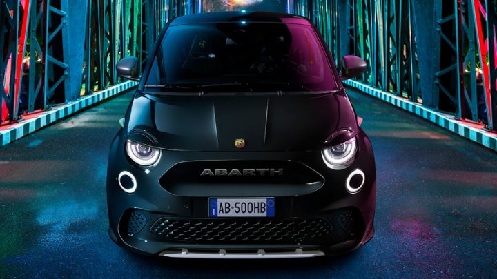 Black Abarth 500e parked in a colourful bridge