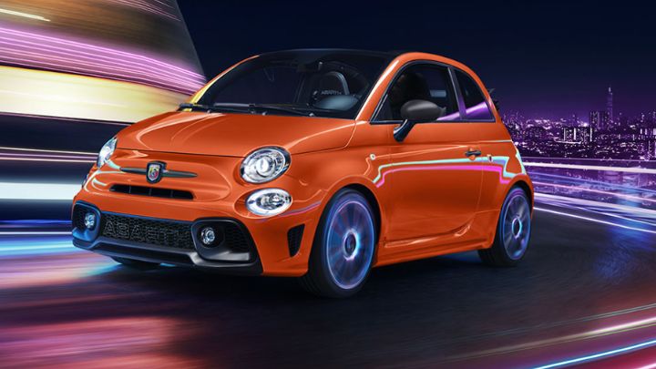 Orange Abarth driving fast through a city