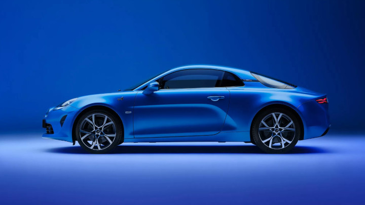 Blue Alpine A110 parked in front of a blue background