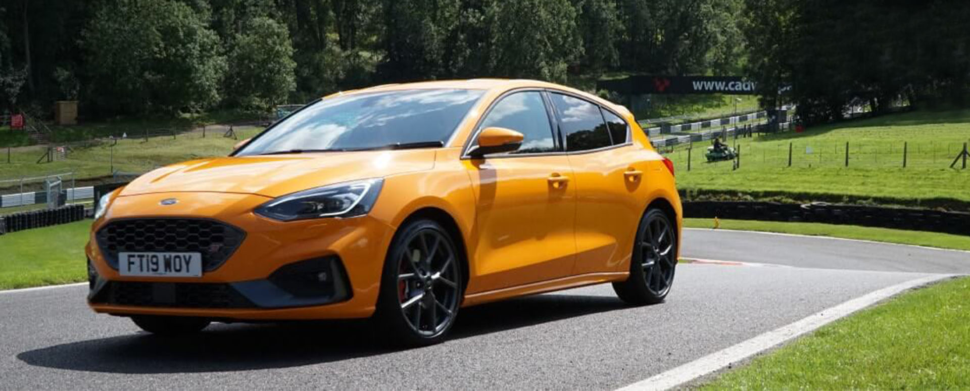 Orange Ford Focus ST driving around Cadwell Park