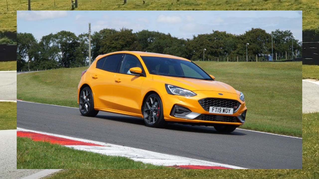 Orange Ford Focus ST driving around Cadwell Park