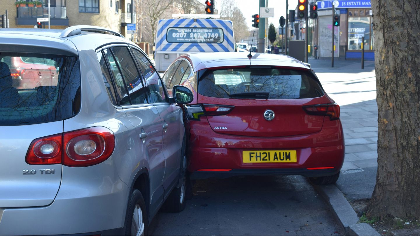 Silver car hitting a red Astra near a traffic light