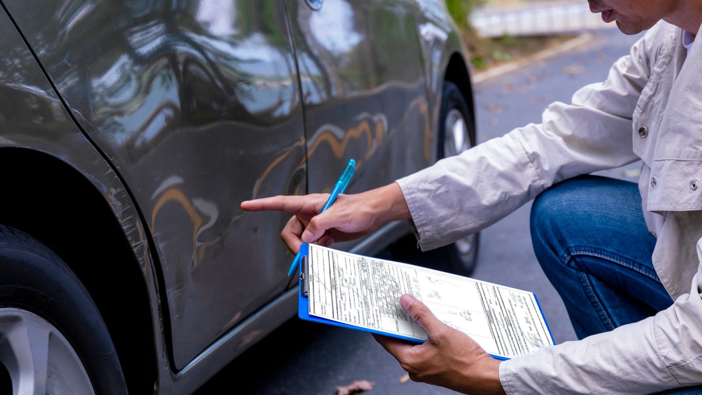 Car insurance man check on a vehicle's dented door