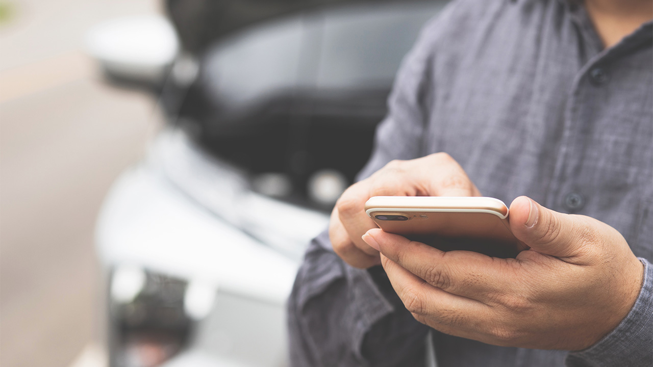 Man calling for assistance with car bonnet open