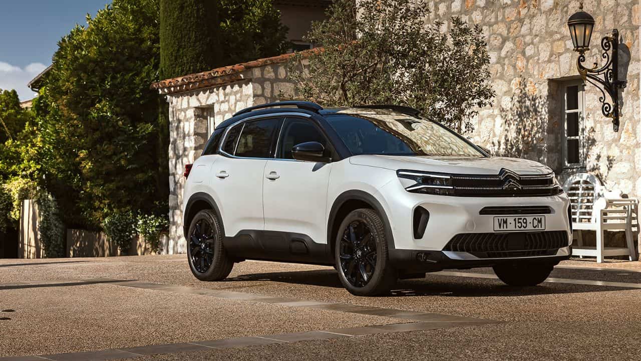 White Citroen C5 Aircross parked in front of a stone house