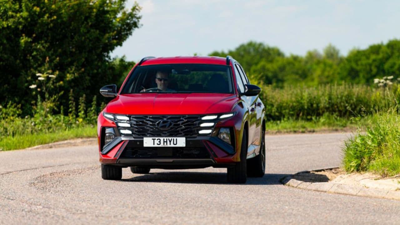 Red Hyundai Tucson driving in the countryside