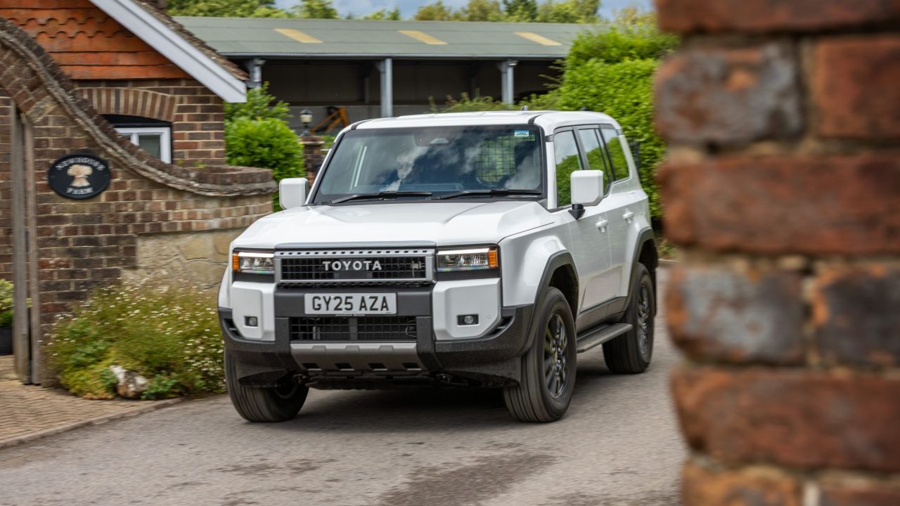 White toyota Land Cruiser driving down road