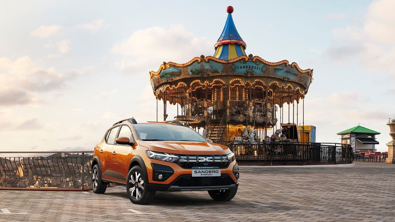 Orange Dacia Sandero Stepway parked in front of a carrousel
