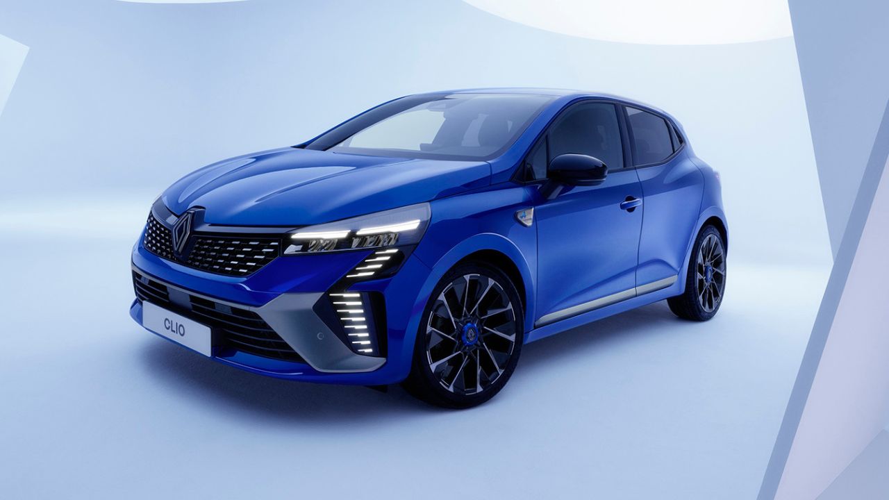 Blue Renault Clio parked in front of an off-white background