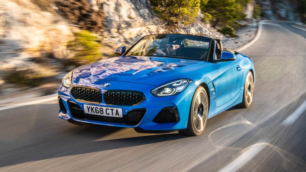 Blue BMW Z4 driving on a road in a mountain