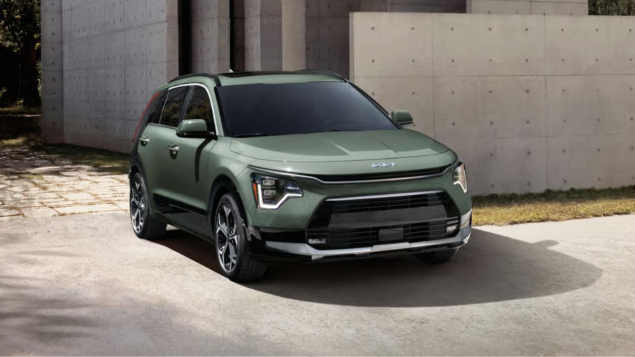 Green Kia Niro parked in front of a grey building