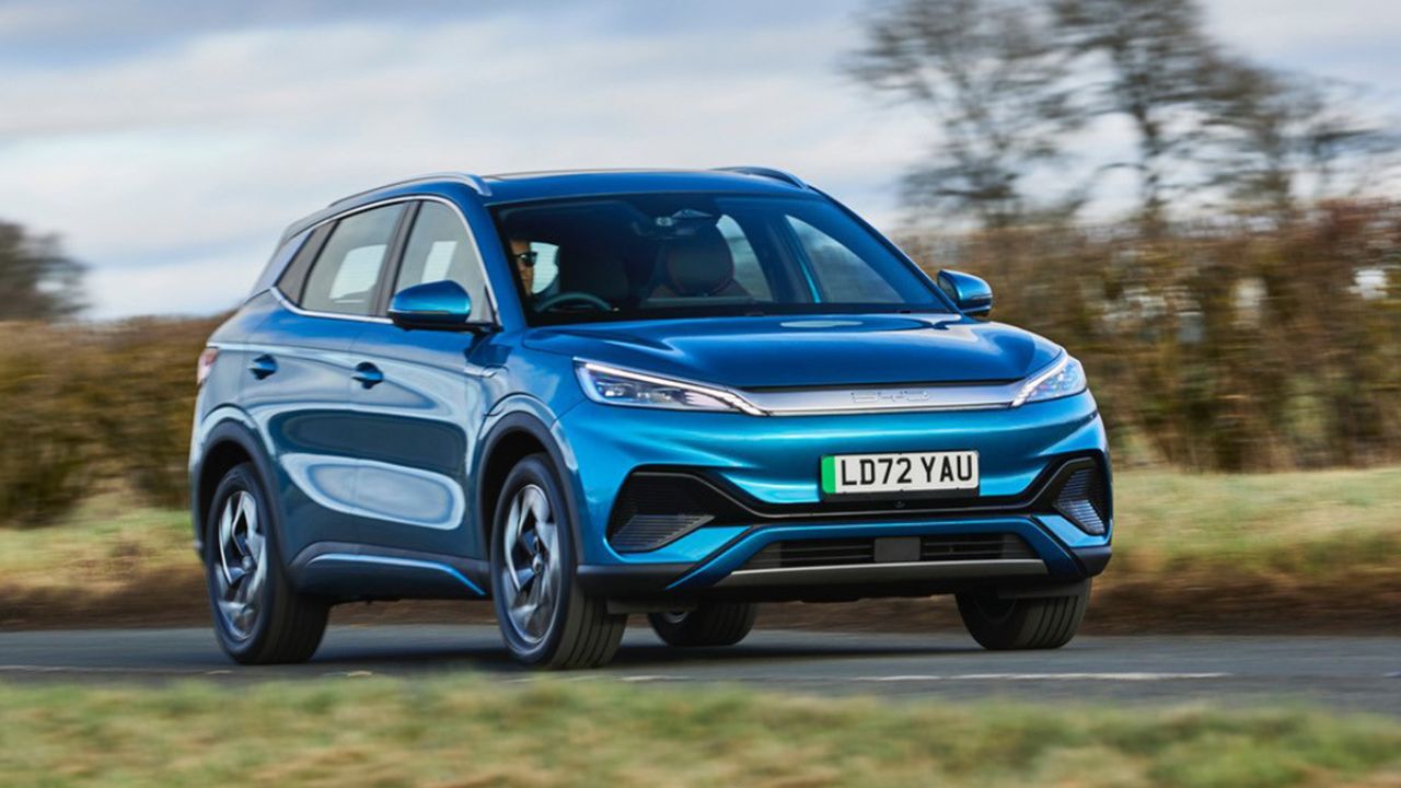 Blue BYD Atto 3 driving in the countryside