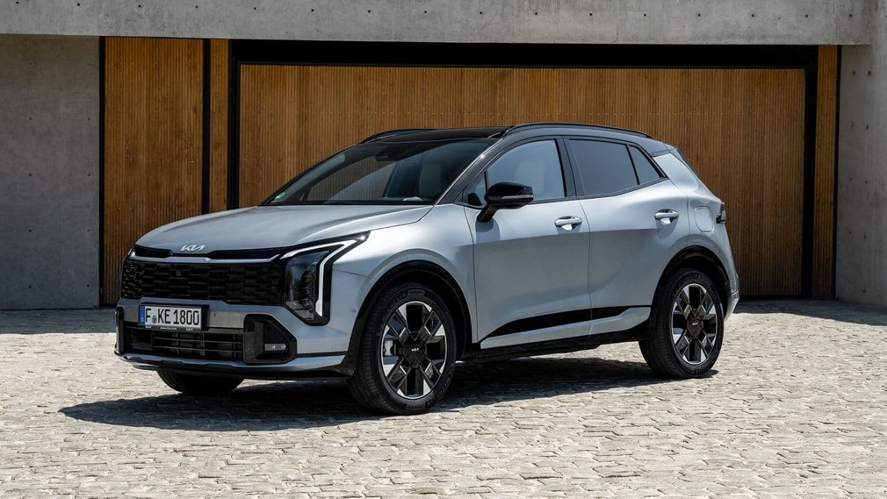 Silver Kia Sportage parked in front of a wooden garage door
