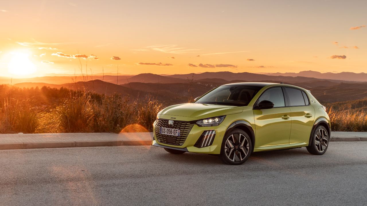 Green Peugeot 208 static at sunset