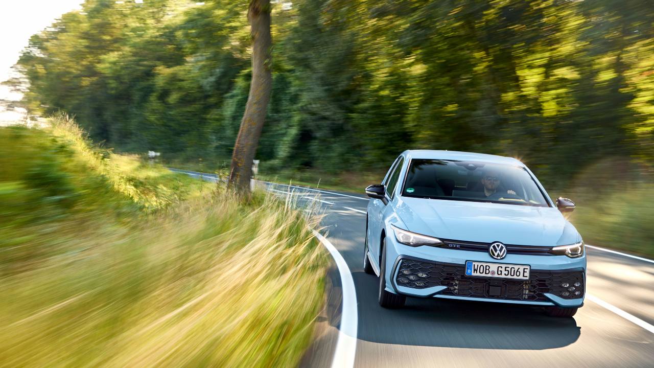 Light blue Volkswagen Golf GTE driving round corner
