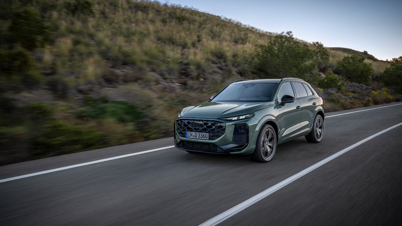 Green Audi Q3 driving sunset