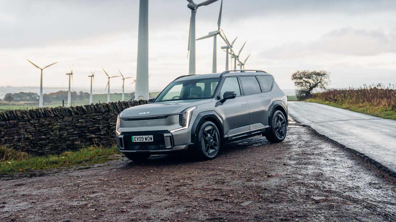 Kia EV9 parked front right with wind turbines behind