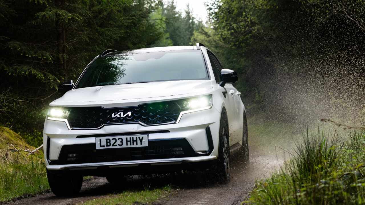 White Kia Sorento driving along muddy road