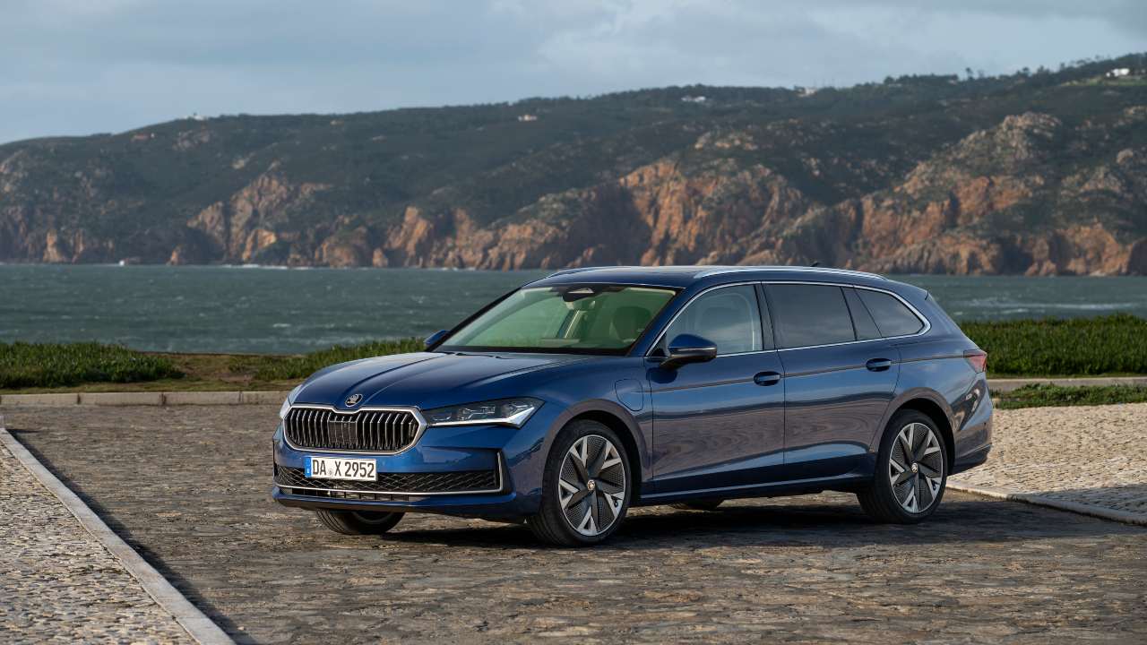 Blue Skoda Superb touring parked mountain background