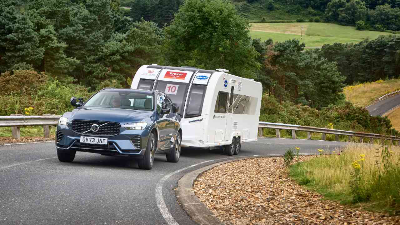 Blue Volvo XC60 towing a white caravan