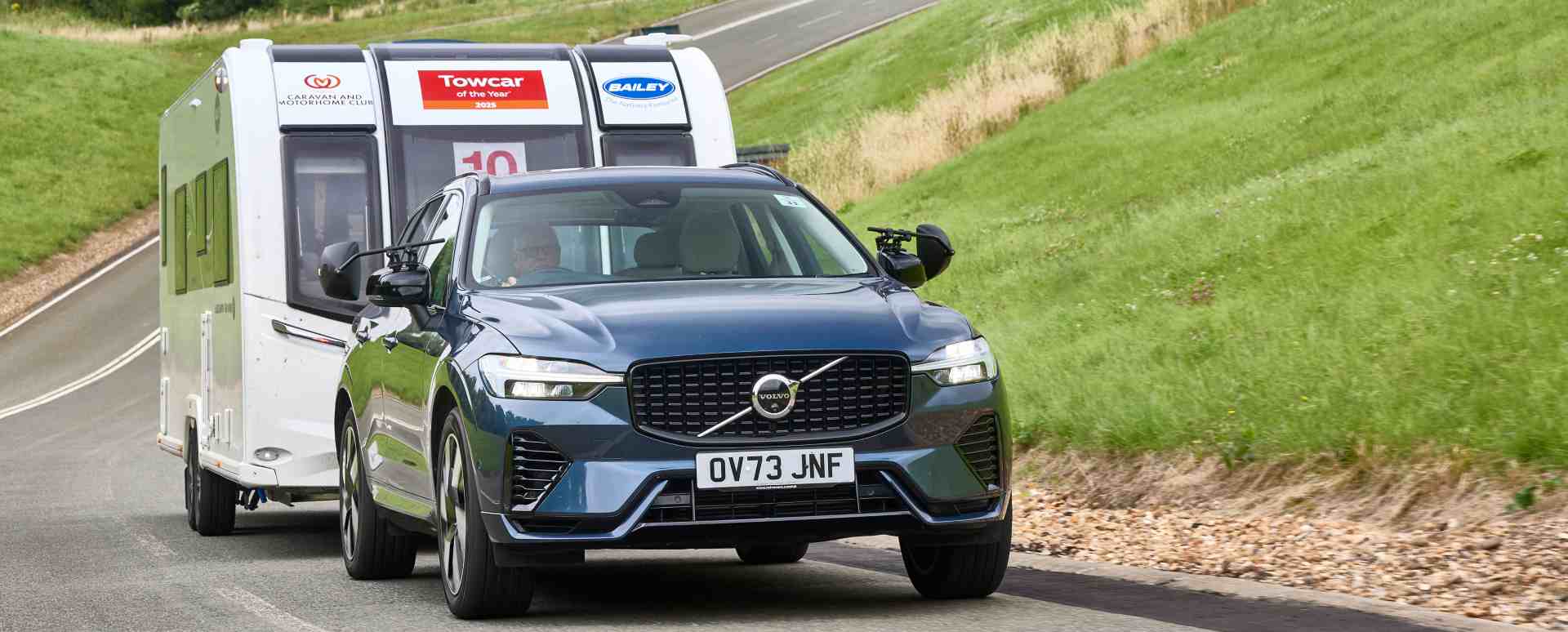 Blue Volvo XC60 towing a white caravan