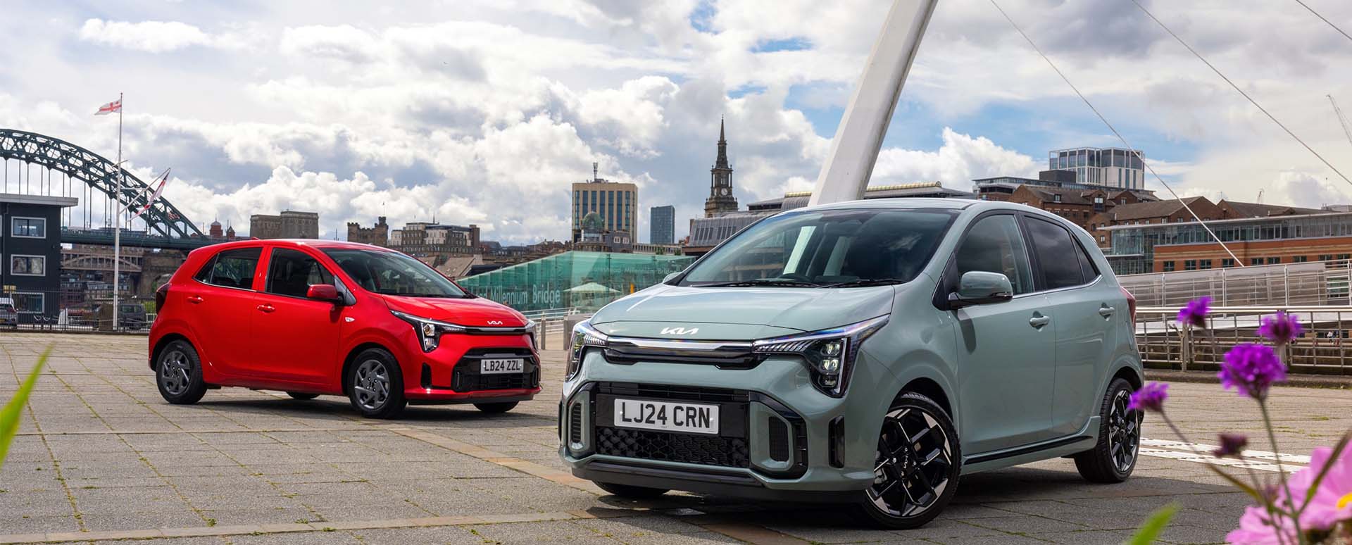 Pair of Kia Picantos red and green near city