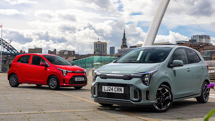 Pair of Kia Picantos red and green near city