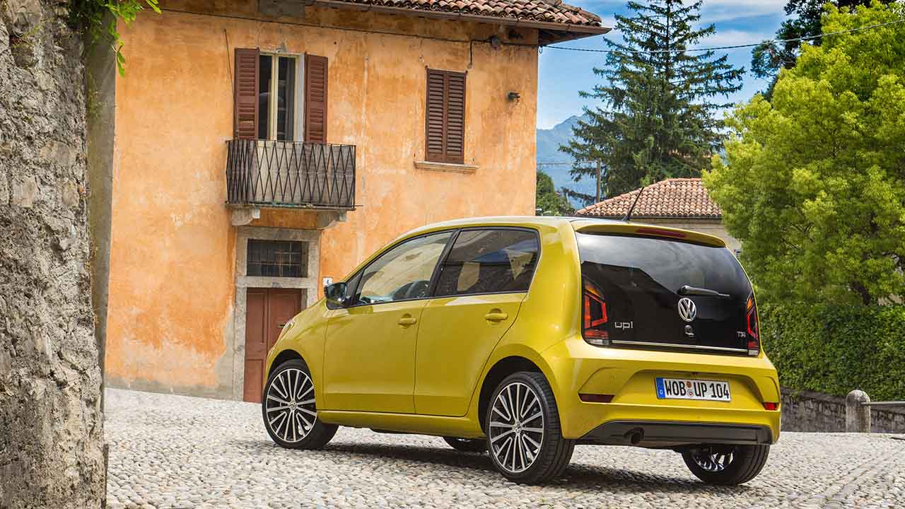 Volkswagen up! yellow near house rear angle