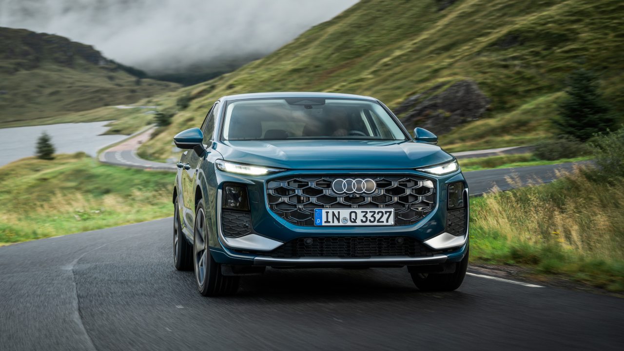 Blue Audi Q3 driving front mountain road