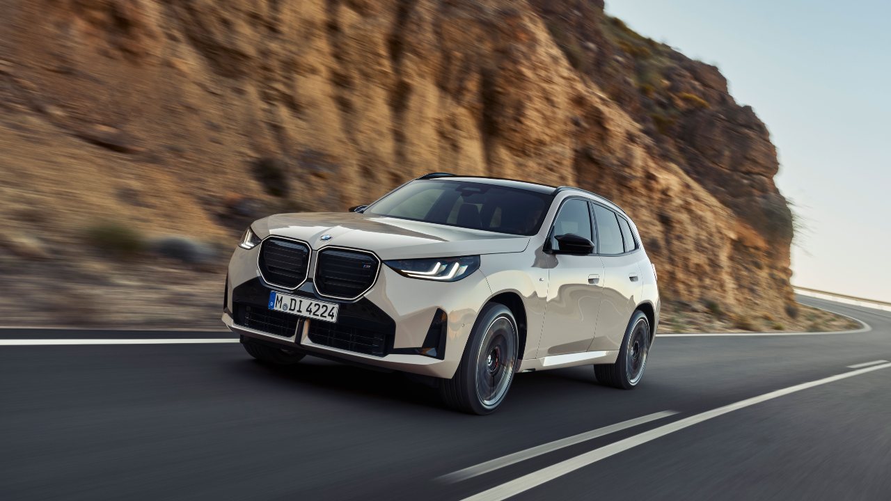 BMW X3 beige driving front right mountain road