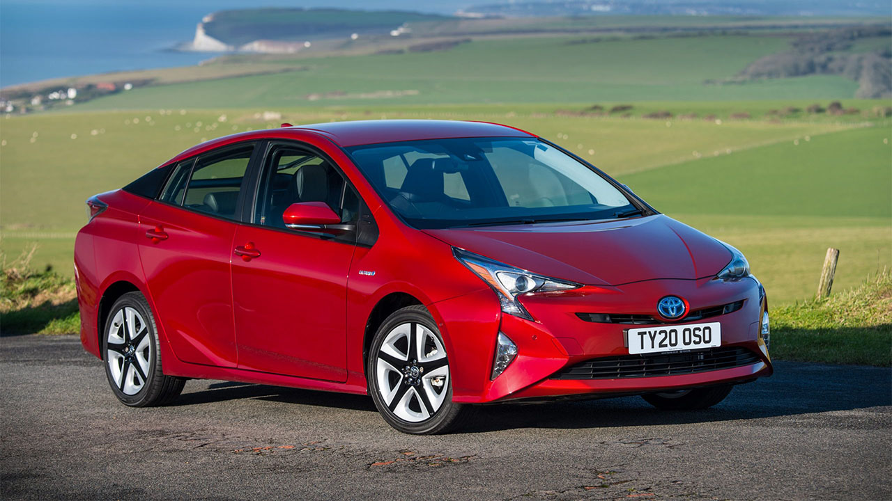 Red Toyota Prius parked in countryside
