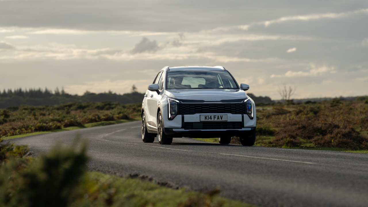 White Kia Sportage driving front