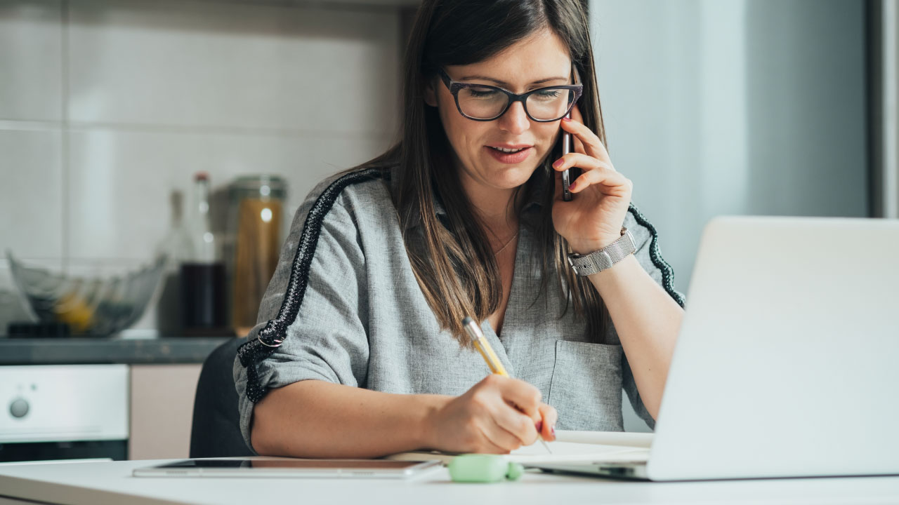 Woman talking on the phone whilst taking notes