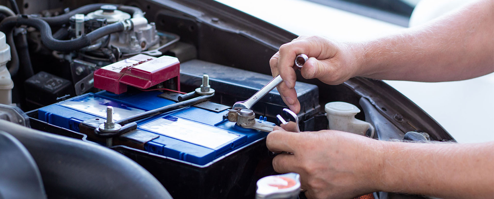 Someone fitting a new battery to a car