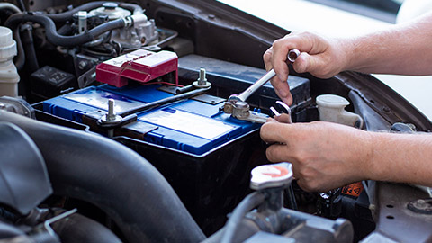 Someone fitting a new battery to a car