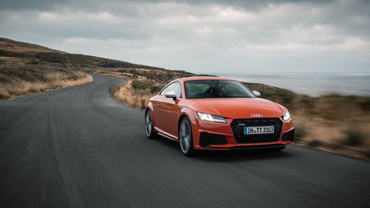 Orange Audi TT driving on coastal road