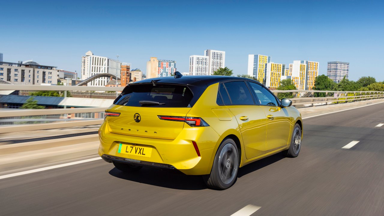Yellow Vauxhall Astra driving rear angle