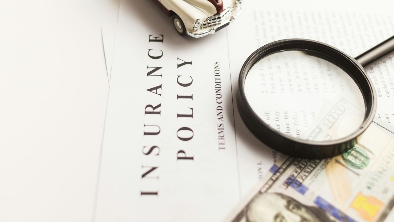 Car insurance policy with a magnifying glass on top of it