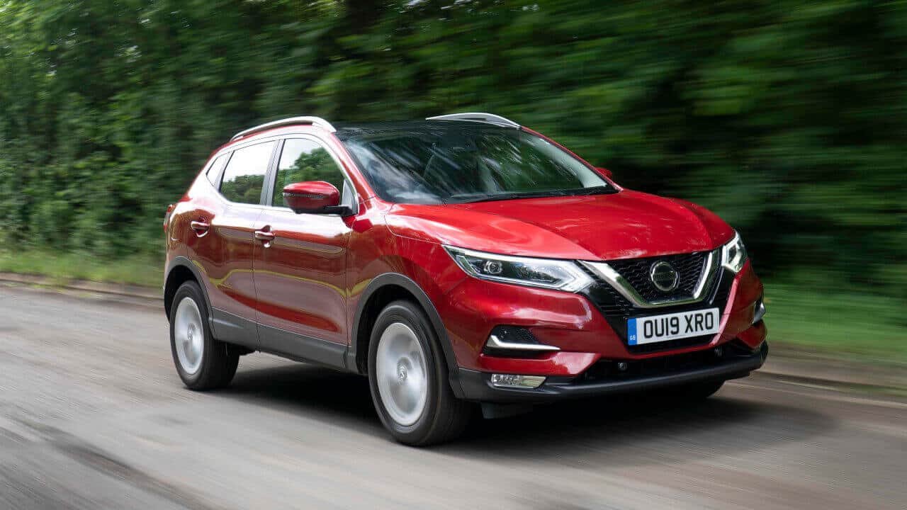 Red Nissan Qashqai driving in the countryside