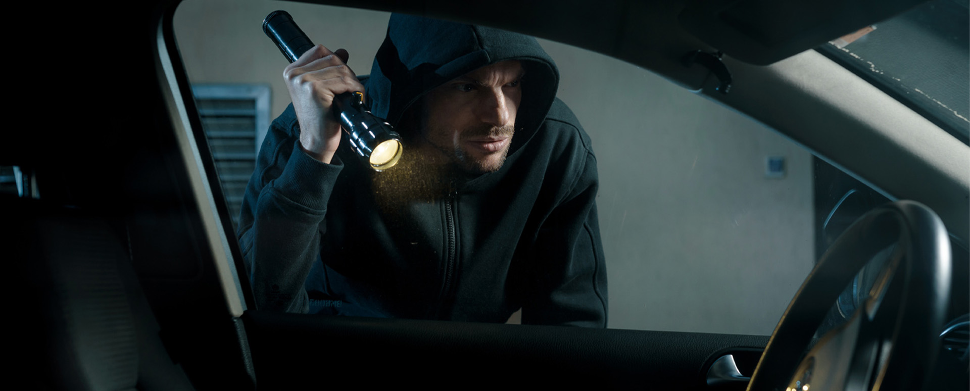 Car thief inspecting the interior of a car