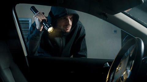 Car thief inspecting the interior of a car
