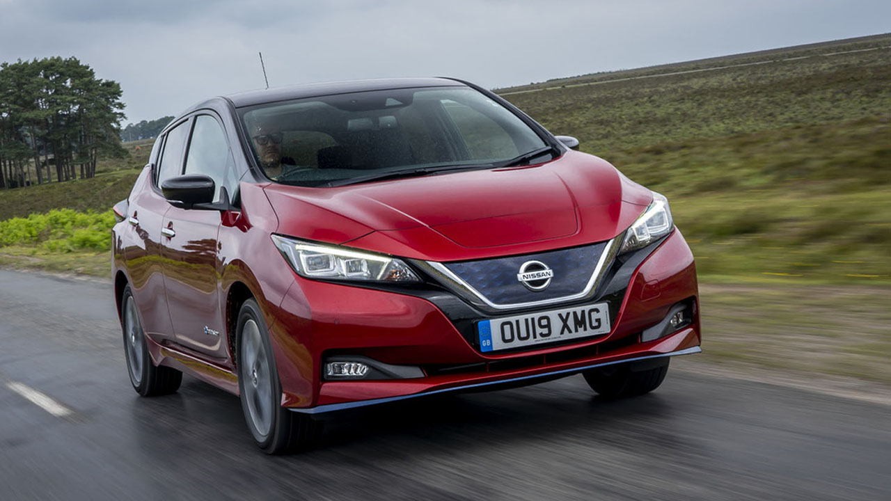 Red Nissan LEAF, driving down country road on wet day