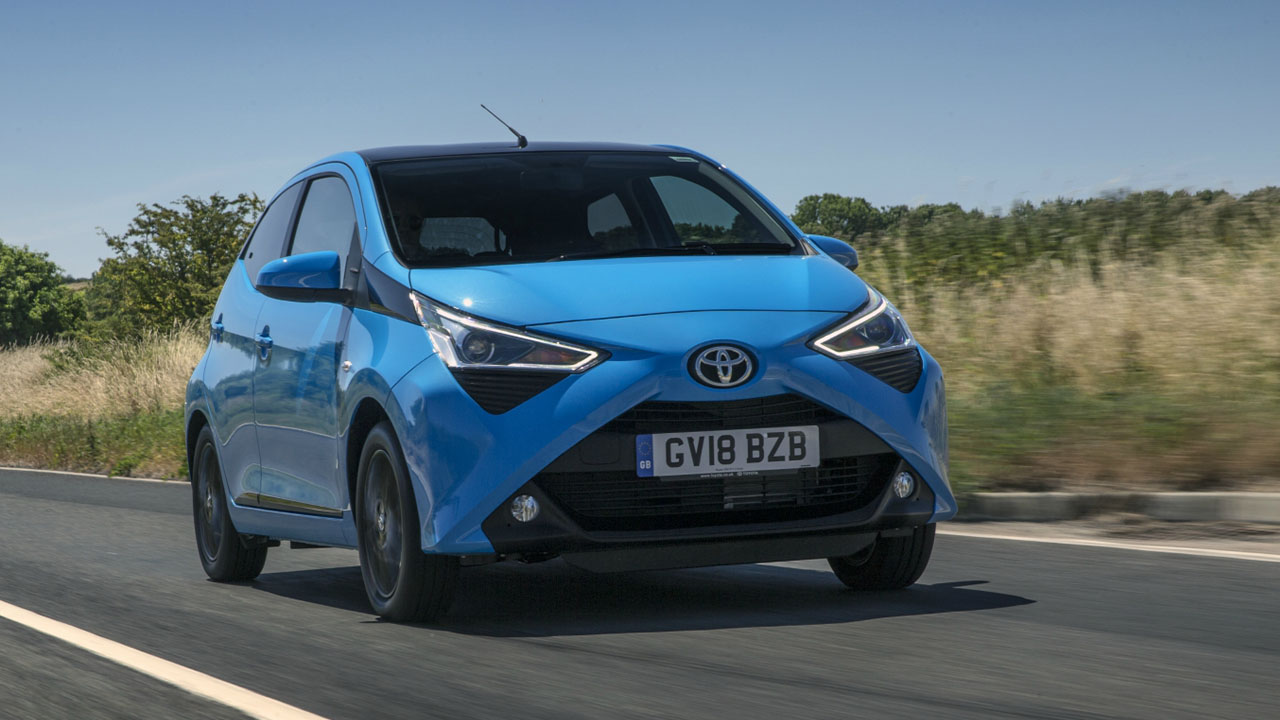 Blue Toyota AYGO, driving on country road