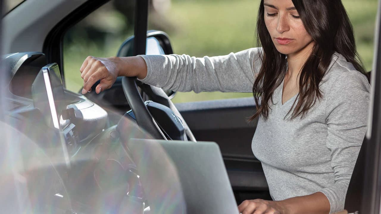 Woman Calculating Finance in Car