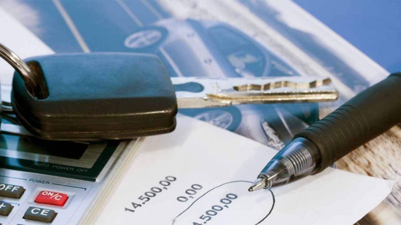 Car key fob sat next to a calculator and pen