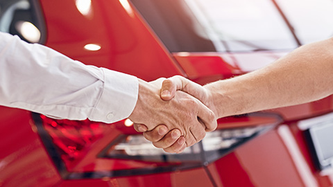 Shaking Hands In Front of Car